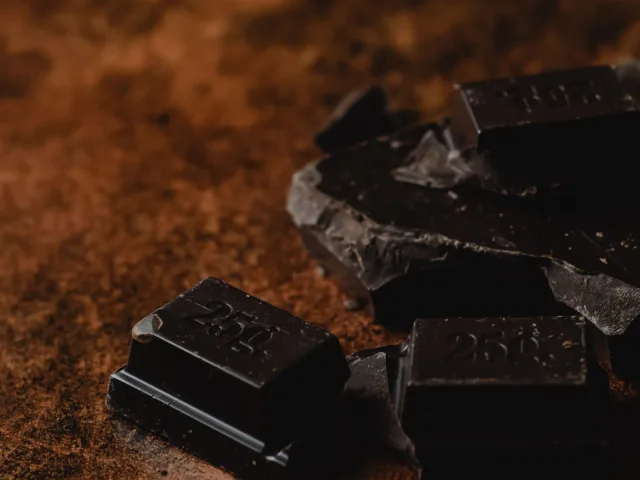 Pedaços de chocolate amargo sobre cacau em pó